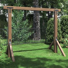 a wooden swing frame sitting on top of a green grass covered field next to a tree