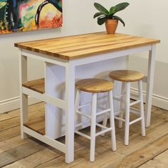 a kitchen island with two stools and a potted plant