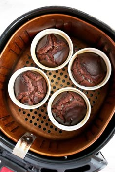 four chocolate cupcakes in the middle of an air fryer