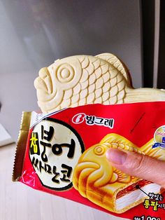 a person holding up a bag of food with fish crackers on it's side