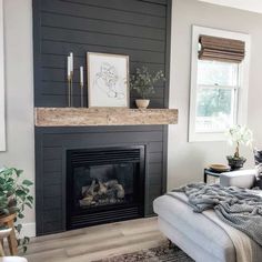 a living room with a couch, fireplace and pictures on the wall above it's mantle