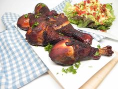 there is a large piece of meat on the plate and a salad in the background