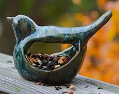 a bird feeder filled with birdseed on top of a wooden table