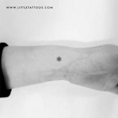 a small snowflake tattoo on the left inner arm and wrist is shown in black and white