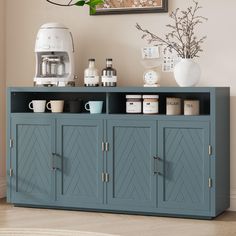 a blue cabinet with coffee cups on it and an art piece hanging above the cabinets