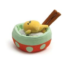 a small stuffed animal in a green and red polka dot bowl with a baseball bat sticking out of it