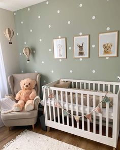 a teddy bear sitting in a chair next to a baby crib with polka dot wallpaper