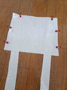 a piece of white paper taped to the floor with red tape and some scissors on it