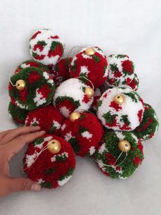 a hand is touching some red and white ornaments