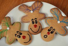 four decorated cookies on a white plate