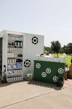 an outdoor display with several items on it and people standing around the area behind them