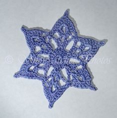 a crocheted blue star on a white surface