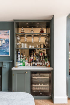 a bar with bottles and glasses on it in a room next to a bed or desk