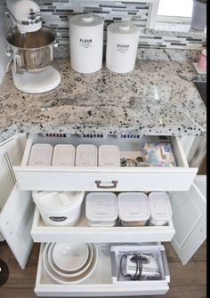 an open cabinet in a kitchen filled with dishes