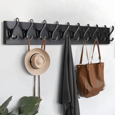 a coat rack with hats and purses hanging from it's hooks on the wall