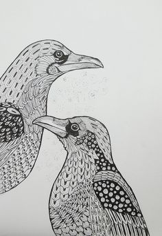 two birds are standing next to each other on a sheet of paper with black ink