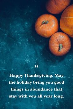 three pumpkins sitting next to each other on top of a blue surface with the words happy thanksgiving, may the holiday bring you good things in abundance that stay