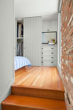 there is a bed and some drawers in this room with wood flooring on the stairs