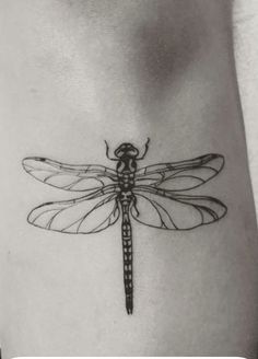 a black and white photo of a dragonfly tattoo