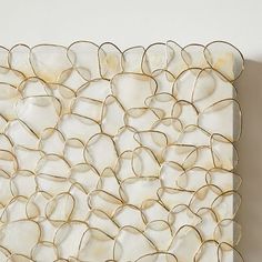 a white and gold wall hanging on the side of a wall