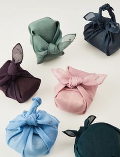 six different colors of hair accessories on a white surface with one knoted in the middle