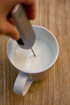 a person is stirring something in a cup