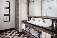 a bathroom with black and white checkered flooring, two sinks and a large mirror