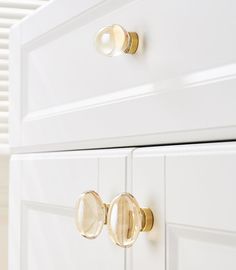 a white dresser with gold knobs and handles