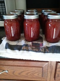 four jars of jam sit on a kitchen towel