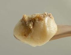 a close up of a wooden spoon with some food on it's tip,