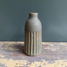 a gray vase sitting on top of a wooden table