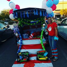 a woman standing in front of a car with balloons and decorations on the back of it