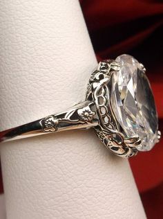 a close up of a ring on a napkin holder with a red cloth in the background