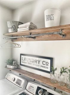 a washer and dryer in a small room with shelves above the washer