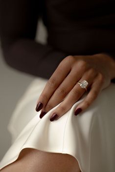 a woman's hand with a ring on top of her arm, sitting down