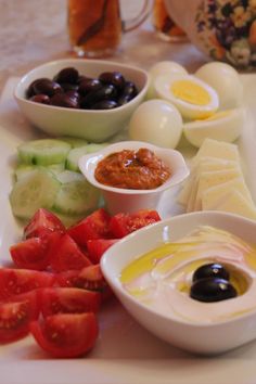 an assortment of food items displayed on a white plate with utensils and sauces