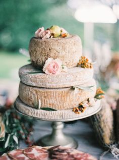 a three tiered cake sitting on top of a wooden table next to other food