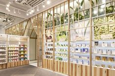 the inside of a store with many shelves filled with products and plants on display in front of them