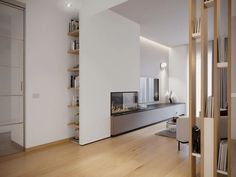 an empty living room with white walls and wooden flooring is seen in this image