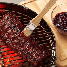 the ribs are being grilled on the bbq grill with black beans and ketchup