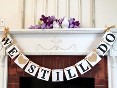 there is a banner that says we are still married on the mantle above a fireplace