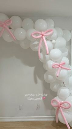 balloon arch with pink bows and white balloons