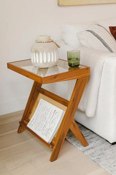 a white couch sitting next to a table on top of a hard wood floor