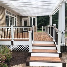 a porch with white railing and wooden steps