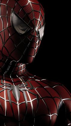 a close up of a spider - man's face and chest in front of a black background