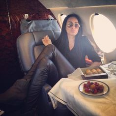 a woman sitting in an airplane with food on the table