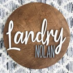 a wooden sign that says landry nolan on the side of a wall in front of a carpeted area