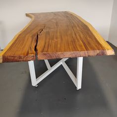 a wooden table with white metal legs and a large piece of wood on it's end