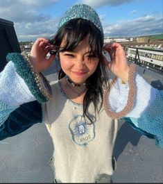 a young woman is posing with her hands on her ears and wearing a cat hat