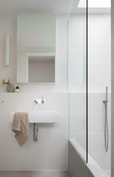 a bathroom with a sink, mirror and bathtub next to a shower head mounted on the wall